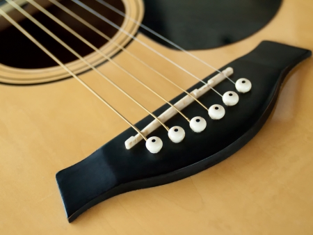 White string pin on wood brown folk guitar 