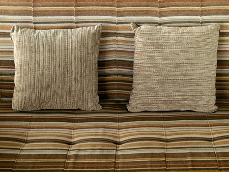 Pillow with brown fabric cover on the Long sofaの写真素材