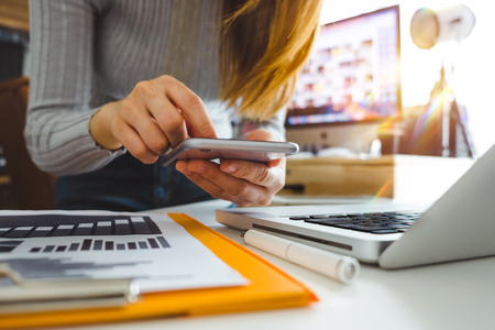businesswoman hand using smart phone,tablet payments and holding credit card online shopping,omni channel,digital tablet docking keyboard computer at office in sun lightの写真素材