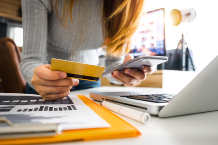 close up of hand using tablet ,laptop, and holding smartphone with credit card online banking payment communication network,internet wireless application development sync app,virtual graphic  icon diagramの写真素材