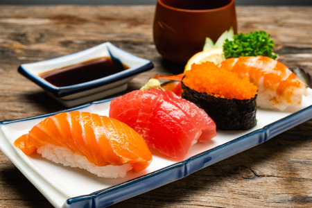 Sushi salmon & tuna sushi shrimp and wasabi on the white plate. on the wood tableの写真素材