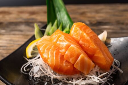 Sashimi, Salmon, Japanese food chopsticks and wasabi on the wood tableの写真素材