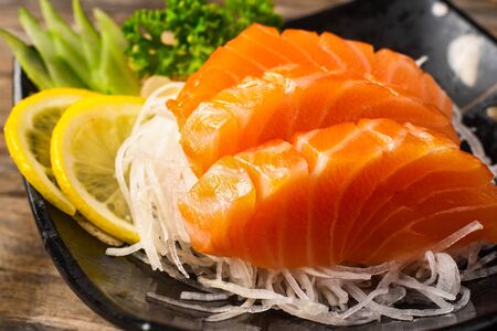 Sashimi, Salmon, Japanese food chopsticks and wasabi on the wood tableの写真素材