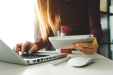 businesswoman hand using smart phone, tablet payments and holding credit card online shopping, omni channel, digital tablet docking keyboard computer at office in sun lightの写真素材