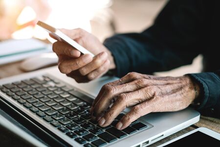 businessman working with digital tablet computer and smart phone with financial business strategy layer effect on desk in morning lightの写真素材