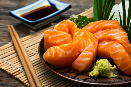Sashimi, Salmon, Japanese food chopsticks and wasabi on the tableの写真素材