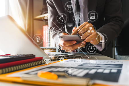 business man hand working with laptop computer, tablet and smart phone in office with digital marketing media  in virtual icon at  office in morning lightの写真素材