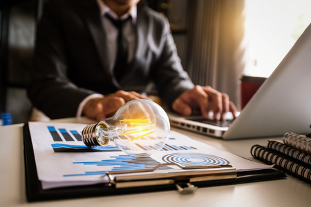 light bulb with business hand working with laptop computer and creative business strategy in morning lightの写真素材