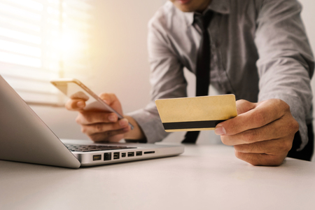 Business man hands using smartphone and holding credit card with digital layer effect diagram as Online shopping conceptの写真素材