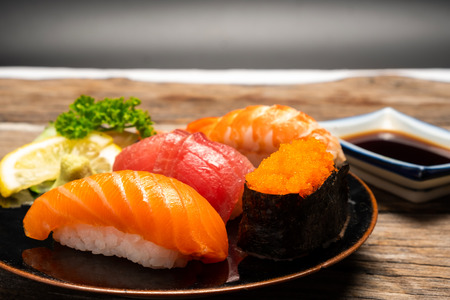 Sushi salmon & tuna sushi shrimp and wasabi on the white plate. on the wood tableの写真素材
