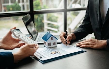 Real estate broker agent presenting and consult to customer to decision making sign insurance form agreement, home model, concerning mortgage loan offer in officeの写真素材