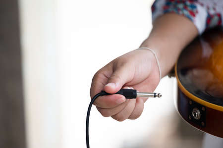 Plug jack cable in electric guitar,Hand inserts input jack to electric guitar