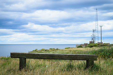 Very old wooden bench with the look at blue sea and the horizonの写真素材