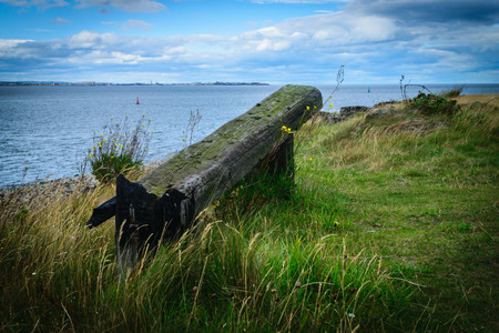 Very old wooden bench with the look at blue sea and the horizonの写真素材