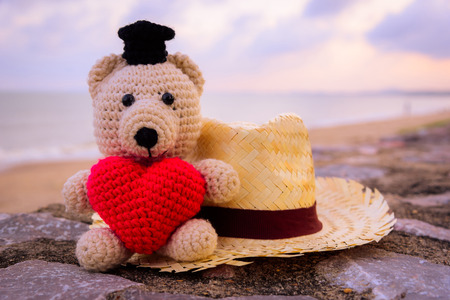 Teddy Bear with red heart sitting near the beach - vintage toneの写真素材