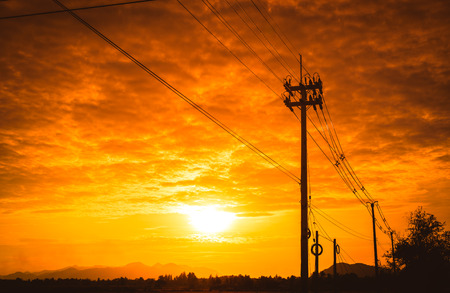 Silhouette electricity post with beautiful sunset background.の写真素材