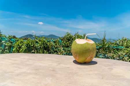 Coconut juice on wood table in blue sky background. Copy space