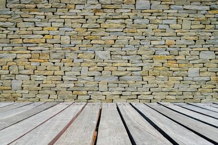 Stone wall background or texture with wooden walkway.の写真素材