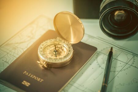 Compass on a US passport and map with blurred old camera. Vintage toneの写真素材
