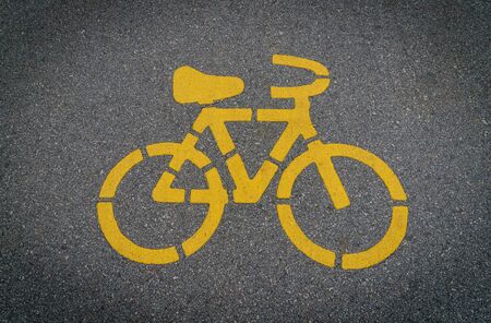 Yellow bycicle sign on lanes asphalt road.の写真素材