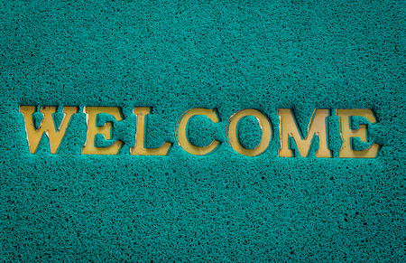 Background of green welcome carpet.