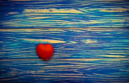 Red heart on blue wooden table background. Vintage toneの写真素材