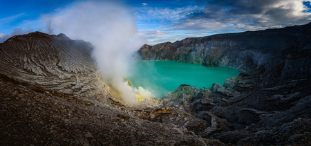 Kawah Ijen volcano with green lake on blue sky background at morning in East Java, Indonesia.の写真素材
