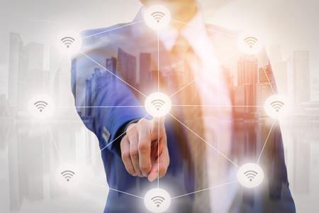 Double Exposure of Businessman pointing finger to screen choice wireless connecting with blurred...