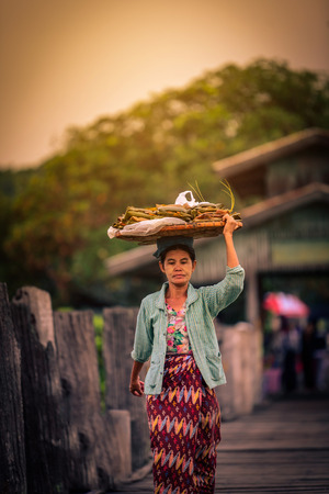 MANDALAY, MYANMAR (BURMA) - December 11, 2017: Myanmar people crossing U Bein wooden bridge at sunrise in Mandalay, Myanmar.のeditorial素材