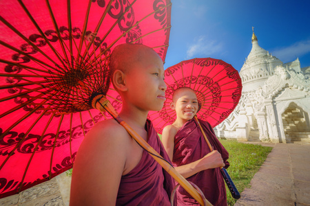 MANDALAY, MYANMAR, -DECEMBER 11, 2017 : Unidentified Two Asian young monk holding red umbrellas on the Mya Thein Tan Pagoda at Mingun, Mandalay Myanmar.のeditorial素材