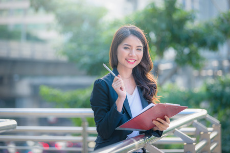 Portrait of business woman happy smile holding check list on clipboard and pen.の写真素材