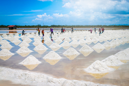 Sea salt fields with piled salt on blue sky background in Thailand.の写真素材