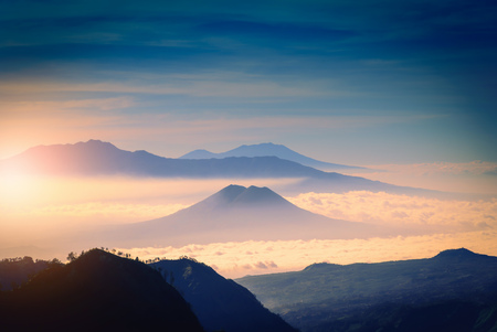 Mountain range in fog with sunlight.
