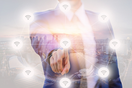 Double Exposure of Businessman pointing finger to screen choice wireless connecting with blurred...