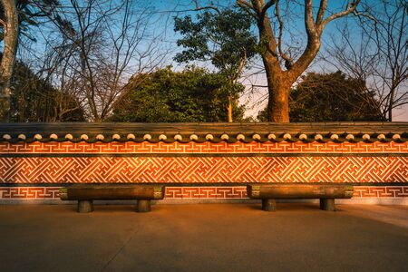 Wooden benches with Korean traditional walls at sunset in South Korea.の写真素材