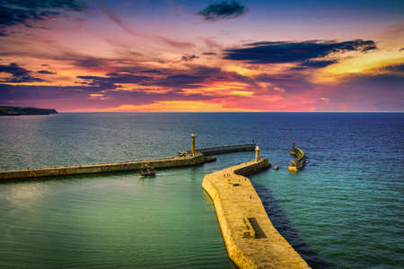 The harbour and lighthouses at sunset in Whitby abbey, North Yorkshire, UKの写真素材