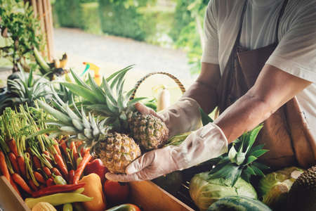 Farmer standing in the farm and selecting vegetables for sale. Selective focus