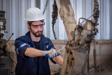 Engineers team mechanic repair Robotic arm for welding steel in steel factory workshop. Industry...