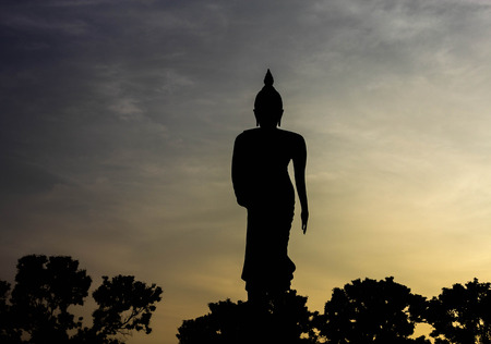 Black shadow Buddha statues on monuments in the evening.の写真素材