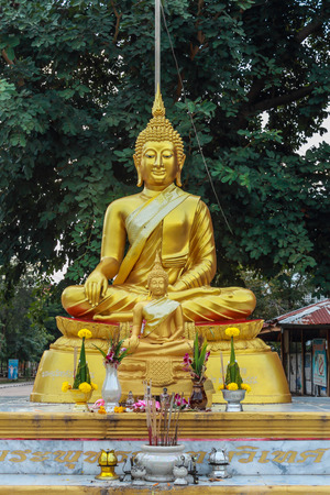 Golden Buddha statue meditating in the shade.の写真素材
