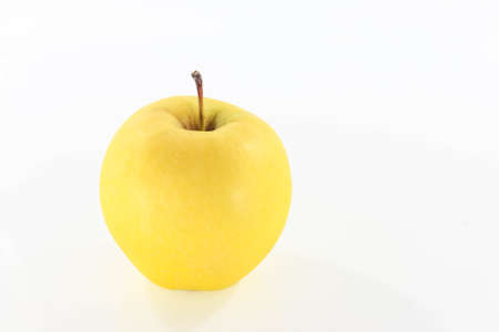 Golden apple that is placed on a white background.の写真素材