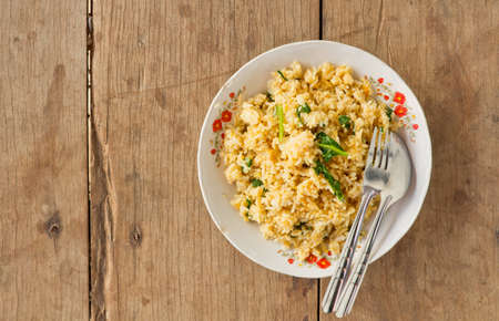 Fried rice dish that is placed on a wooden board.の写真素材