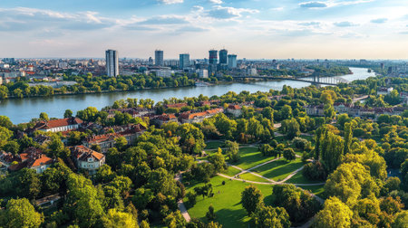 Clear summer day in Belgrade, view from Ada Bridge to city center with green parks, red rooftops, and river viewsの素材