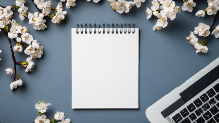 Sophisticated minimalist flat lay featuring a blank notepad, delicate floral shadows, and a laptop keyboard.の素材