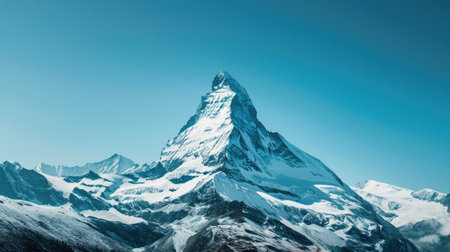 Majestic mountain peak covered in snow under a clear blue skyの素材