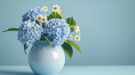 Minimalist ceramic vase with a sleek silhouette, displaying a fresh bouquet of blue hydrangeas and white daisiesの素材