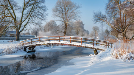 A snow-covered bridge crossing a frozen river in a picturesque winter landscape.の素材