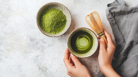 Top view of a cup of matcha green tea with a bamboo whisk and a bowl of matcha powderの素材