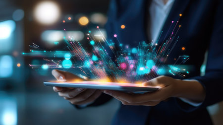 A business professional using a tablet with holographic data visualizations, representing big data analytics and digital transformation in the smart industryの素材