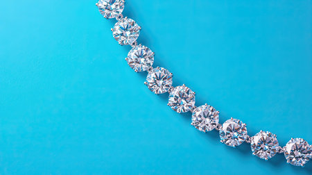 A beautiful diamond necklace arranged on a bright blue background, captured from a high angle, with each diamond glistening against the vibrant colorの素材